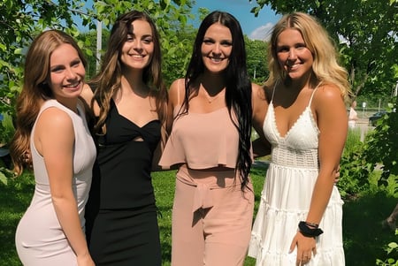 Cuatro alumnas están en el área verde exterior del terreno de la Nantyr Shores Secondary School.