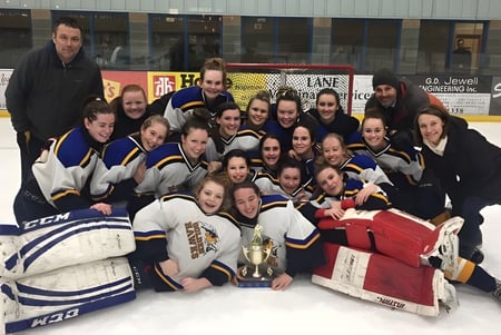 Las estudiantes de la Napanee District Secondary School celebran con un trofeo su victoria en el hielo.