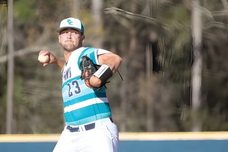 Un jugador de béisbol en uniforme azul y blanco está en el campo en el campus del New Brunswick Community College.