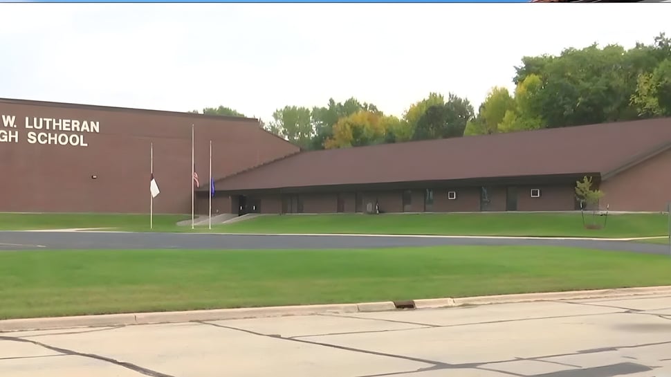 El gran edificio marrón de la N.E.W. Lutheran High School está rodeado de una superficie de hierba y árboles.