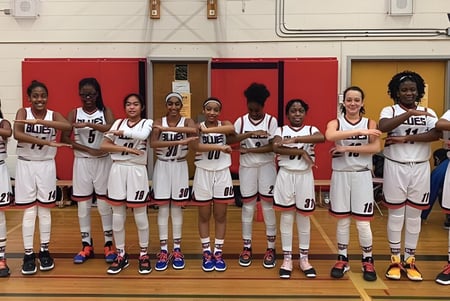 Un grupo de jóvenes jugadoras de baloncesto se encuentra en el gimnasio de la Newtonbrook Secondary School.