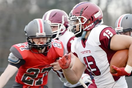 Jugadores de fútbol de la Niskayuna High School juegan en el campo en una situación de juego.
