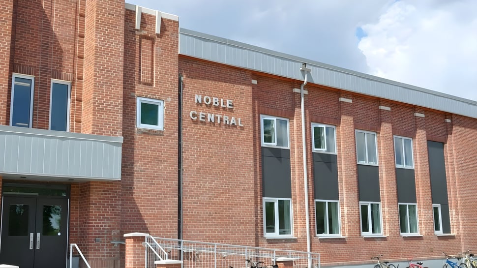 El edificio de ladrillo de varios pisos de la Noble Central School bajo un cielo nublado.