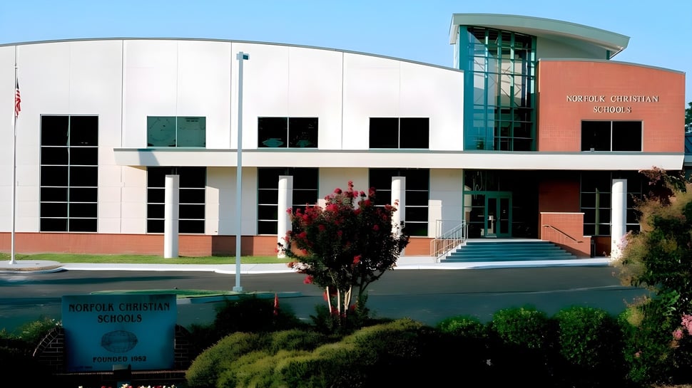 El moderno edificio de varios pisos con fachada curva en el campus de Norfolk Christian Schools.