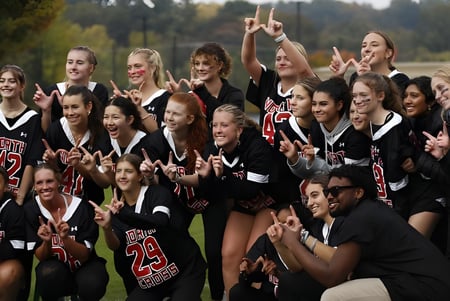 Un grupo de estudiantes de la North Cross School celebra juntos en un campo de deportes.