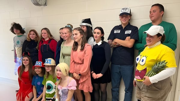 Estudiantes de la North Dundas District High School se reúnen en coloridos disfraces en un aula.