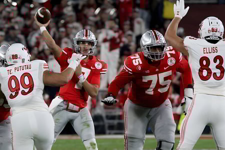 Los jugadores de fútbol de la Northeastern Wisconsin Lutheran High School celebran en el campo frente a la multitud animada.