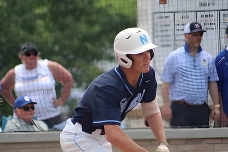 Un joven jugador de béisbol está en uniforme en primer plano en el terreno deportivo de la Northpoint Christian School.