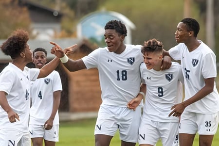 Un grupo de jóvenes futbolistas celebra juntos en el campo de fútbol de la Northwood School.