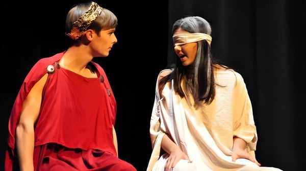 Dos estudiantes en trajes coloridos están en el escenario del teatro de la Oak Mountain Academy.