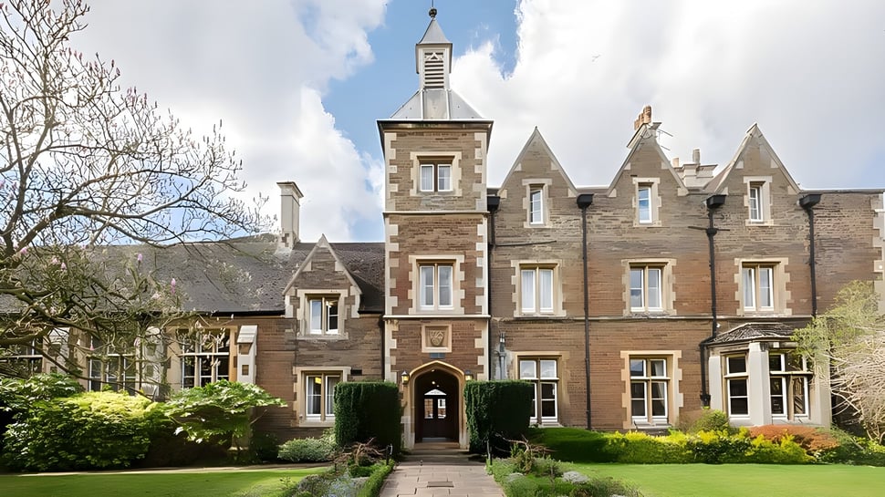 El edificio histórico de la Oakham School se asemeja a un castillo de piedra con una alta torre y está rodeado de cuidadosos espacios verdes.