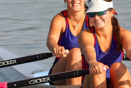 Dos mujeres en trajes de baño coloridos están sentadas en un barco disfrutando del día soleado en el agua en el Odenz Programm.