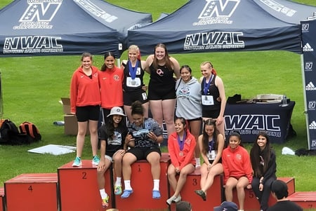 Jóvenes deportistas del Olympic College están en un podio durante un evento WAC.