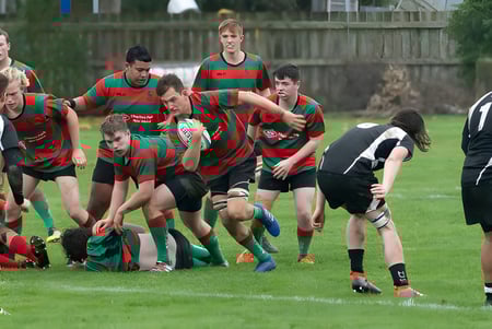 Un grupo de jugadores de rugby en un scrum en el campo de deportes de Onslow College.