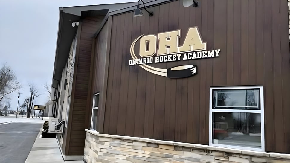 Se puede ver el edificio de la Ontario Hockey Academy con revestimiento de madera y el logo en la parte frontal.