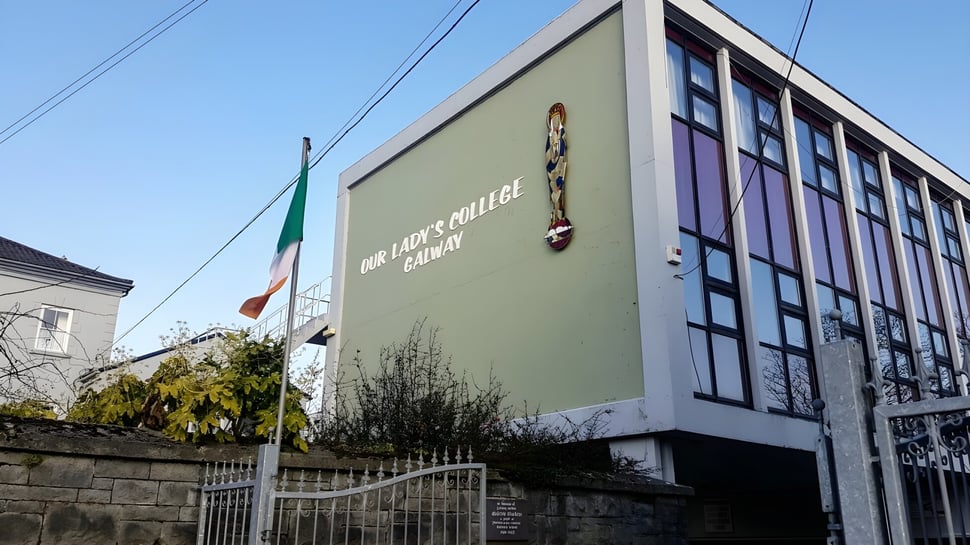 El edificio de varios pisos con fachada verde y grandes ventanas se encuentra en el terreno de Our Lady's College.
