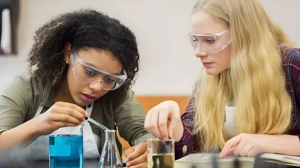 Dos estudiantes de Our Lady's College se concentran en un experimento científico en el laboratorio.