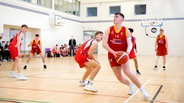Estudiantes de Our Lady’s Secondary School juegan baloncesto en el gimnasio.