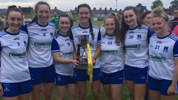 Un grupo de deportistas de la Our Lady’s Secondary School sostiene un trofeo en el campo de deportes.