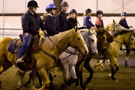 Estudiantes de Our Lady’s Secondary School montan a caballo en un picadero.