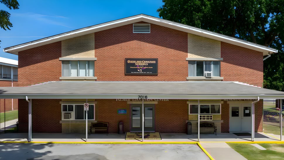 El Coon Creek Community Center en el terreno de las Overland Christian Schools se encuentra en un área cubierta de hierba con árboles al fondo.