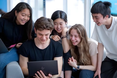 Estudiantes del Oxford International College Brighton trabajan juntos en un portátil.