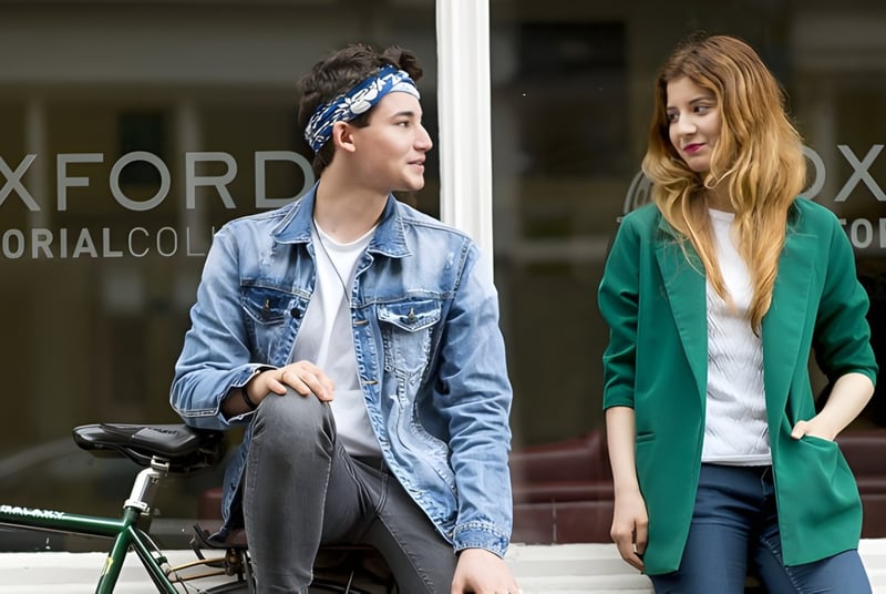 Dos estudiantes están frente al edificio del Oxford Sixth Form College con un letrero visible.