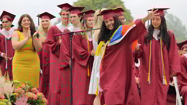 Un grupo de graduados de la Palm Beach Currumbin State High School está junto a un fondo de plantas verdes.