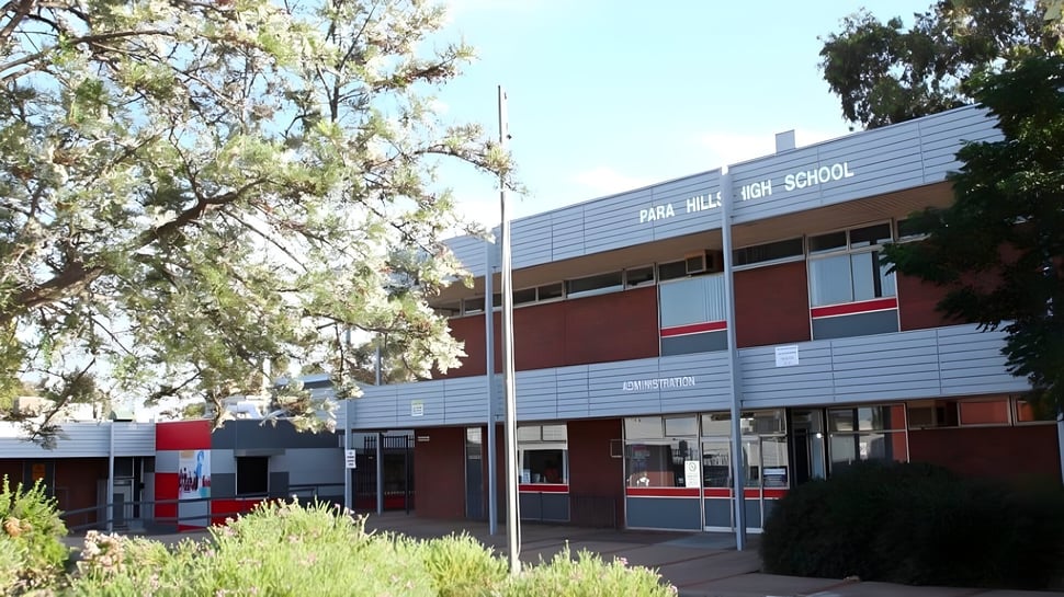 El edificio de Para Hills High School está rodeado de árboles y plantas verdes.