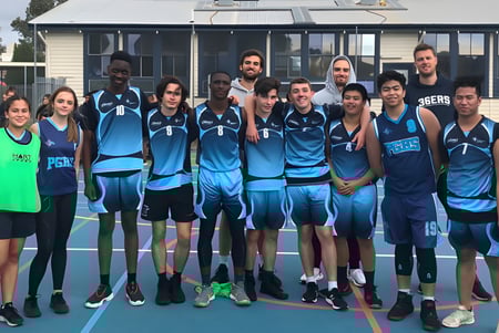 Un grupo de jóvenes atletas está en la cancha de baloncesto de la Parafield Gardens High School.