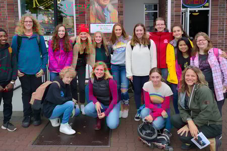 Un grupo de estudiantes está en el área exterior de la Parkland Secondary School frente a un edificio de ladrillo.