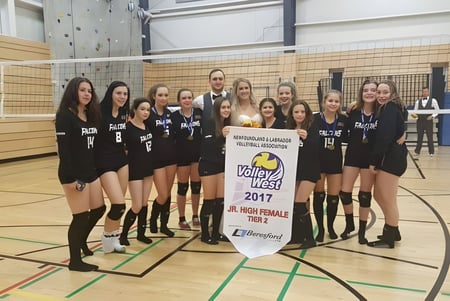 Un grupo de jugadoras de voleibol sostiene un banner de campeonato en el gimnasio de la Pasadena Academy.