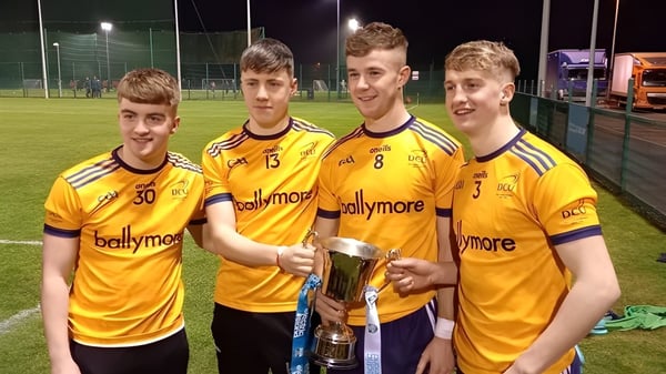 Un grupo de estudiantes de la Patrician High School está en el campo de deportes sosteniendo un trofeo.