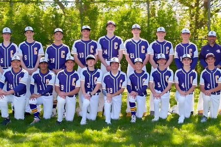 Un grupo de estudiantes se encuentra en el campo deportivo de la Peoria Christian School y se prepara para jugar béisbol.