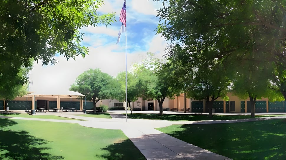 El campus verde de la Phoenix Christian Preparatory School con un camino hacia un edificio y una bandera americana.