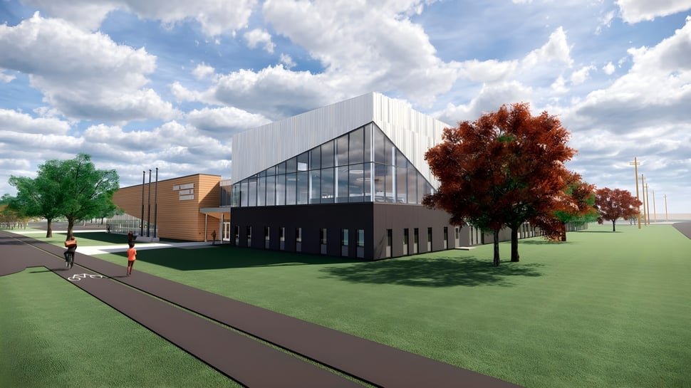 El moderno edificio de la École secondaire publique Pierre de Blois está rodeado de árboles de colores otoñales y césped verde bajo el cielo nublado.