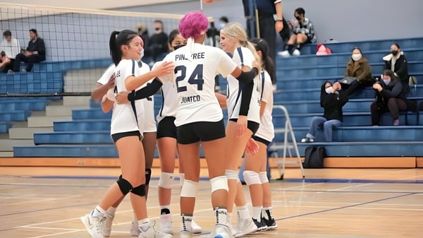 Las jugadoras de voleibol de la Pinetree Secondary School se agrupan en la cancha de baloncesto durante un partido.