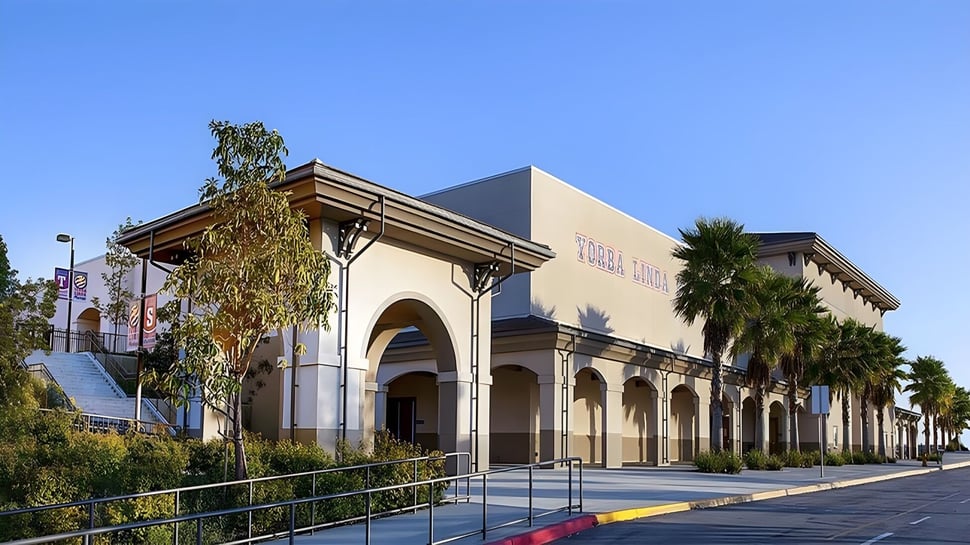 El edificio del Placentia-Yorba Linda Unified School District muestra una entrada decorada y palmeras bajo un cielo despejado.