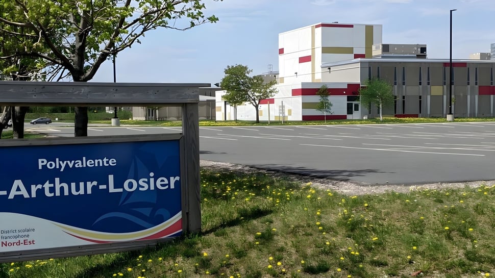 El moderno edificio de varios pisos de la Polyvalente W.-A.-Losier está rodeado de árboles y una superficie de césped.