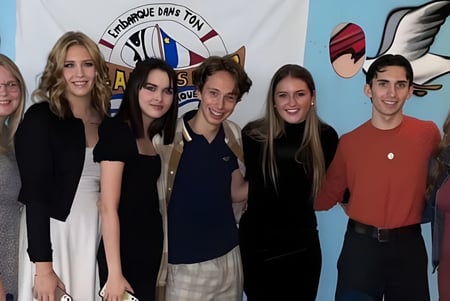 Estudiantes de la Polyvalente W.-A.-Losier están frente a un colorido mural con la inscripción Storrington High School.