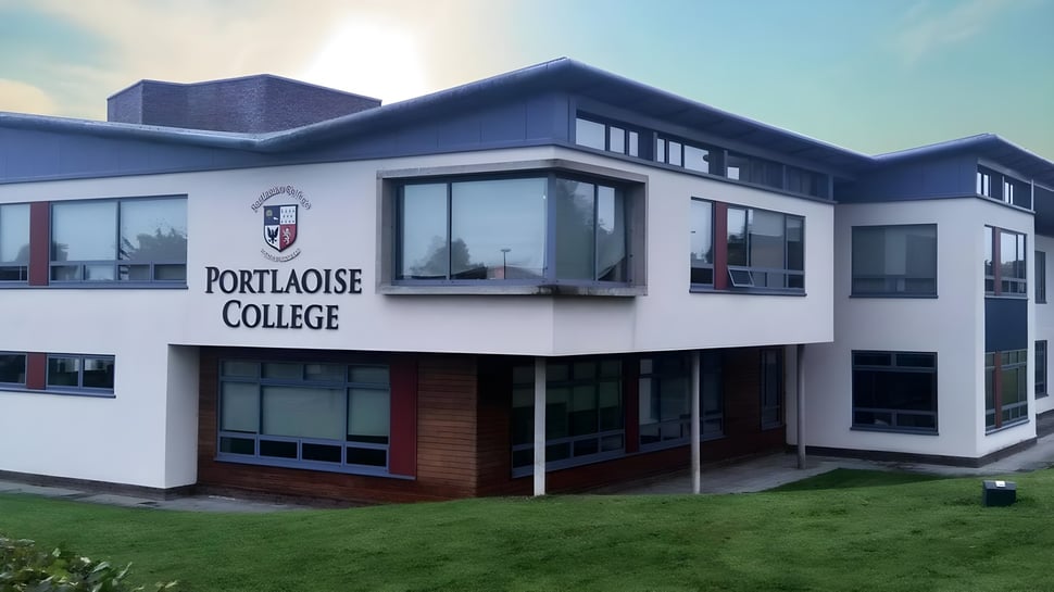 El moderno edificio de varios pisos del Portlaoise College está rodeado de una zona verde en primer plano.