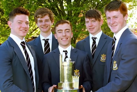 Alumnos de Presentation College Galway posan al aire libre junto con un trofeo.
