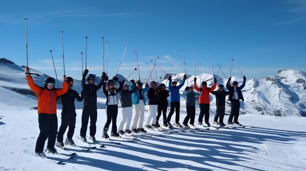 Un grupo de estudiantes de la Presentation Secondary School (Thurles) está en una ladera nevada bajo un cielo despejado.