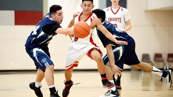 Dos estudiantes juegan baloncesto en competición en el campo deportivo de la Prince George Secondary School.
