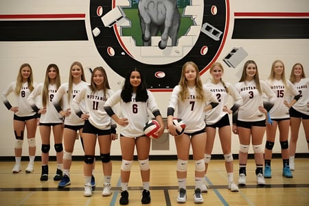 Un grupo de jugadoras de voleibol de la Princess Margaret Secondary School está reunido en el gimnasio.