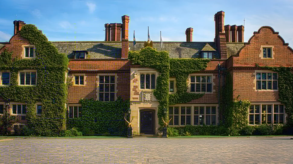 El histórico edificio de ladrillo de Queen Ethelburga’s Collegiate está rodeado de muros cubiertos de hiedra.