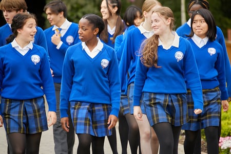 Estudiantes de Queen Ethelburga’s Collegiate están juntos en el área del jardín de la escuela.