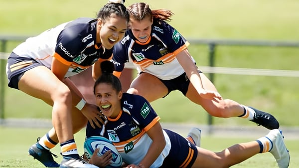 Un grupo de jugadoras de rugby realiza un tackle en el campo deportivo de la Queen Margaret's School for Girls.