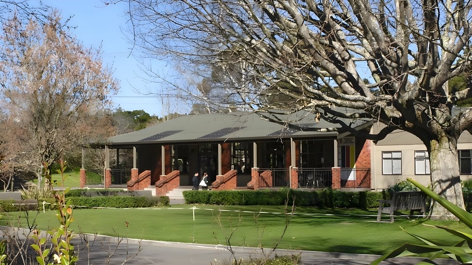 El edificio de ladrillo con entrada cubierta y césped cuidado en el terreno del Rathkeale College.