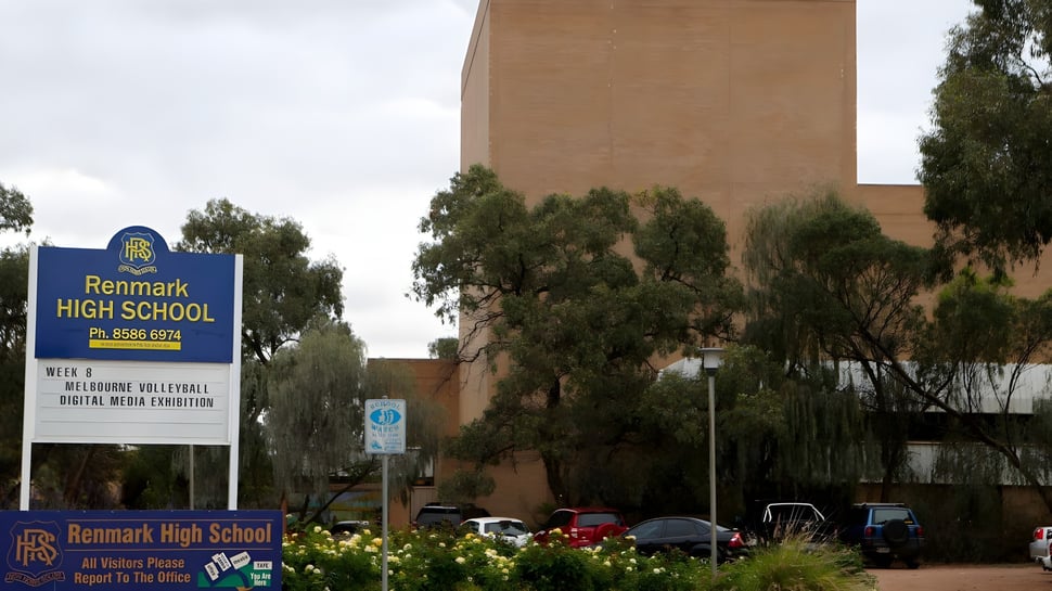 El gran edificio de ladrillo con el letrero Renmark High School está rodeado de árboles y otros edificios.